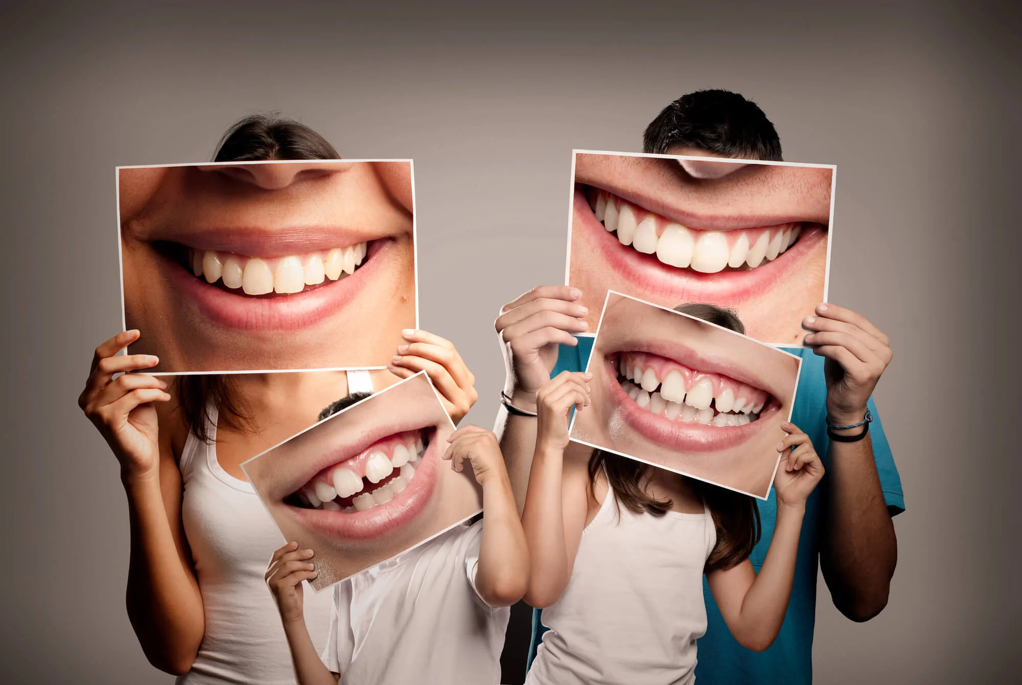 Young-family-holding-a-picture-of-a-mouth-smiling-after-visiting-a-family-dentist-in-Bethesda-MD