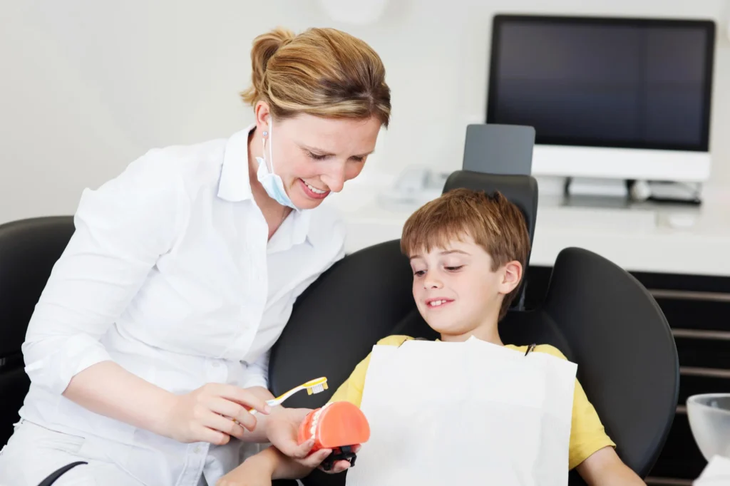 Dentist for kids in North Bethesda, MD providing brushing tips to a boy.